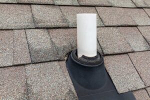 A homeowner measures roof slope with a level and tape measure inside a bright attic.